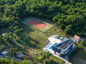 una vista aerea di un edificio con un campo da tennis di Villa Nella Foresta with private 66sqm heated pool, Whirlpool, Tennis court, Gym, Billiards, 4 en-suite bedrooms a Radošić