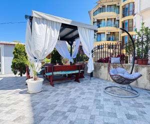 a patio with a canopy and a bench and a table at Villa SUN in Kiten