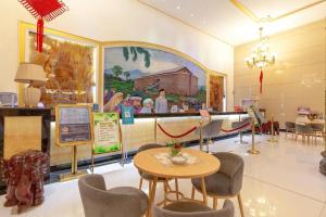 a restaurant with a table and chairs and a painting on the wall at Kunming Noah's Ark Hotel in Kunming