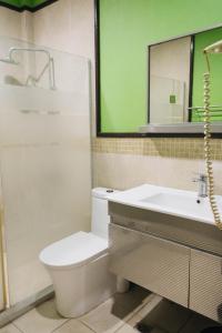 a bathroom with a toilet and a sink and a mirror at La Traviesa Hotel Resort in General Trias