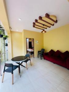 a living room with a red couch and a table at Calangute Beach Inn Goa in Calangute +43 photos
