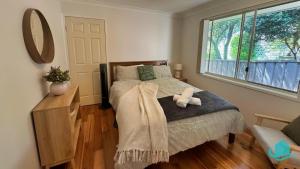 a bedroom with a bed with a teddy bear on it at Balcolyns Beauty - the ultimate lakeside escape in Eraring