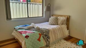 a small bedroom with a bed and a window at Balcolyns Beauty - the ultimate lakeside escape in Eraring
