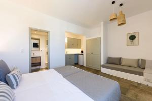 a white bedroom with a bed and a couch at Phaedrus Living Paros Cycladic Residences 3 in Kampos Paros