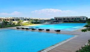 a large pool with blue water in front of a building at Stylish 2BR Near Food - Shops-Fast WiFi-Late Checkin in Gedong