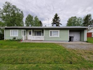 a green house with a lawn in front of it at Hiitolantie 4 in Härmä