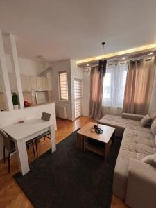 a living room with a white table and a couch at Centar stan na dan Ub in Ub