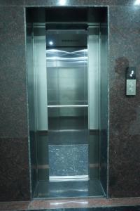 a glass elevator in a building with a glass door at Kukkeshree Heights in Subrahmanya