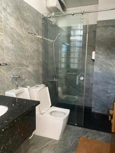 a bathroom with a toilet and a glass shower at Duy Thảo Hotel in Da Lat +47 photos