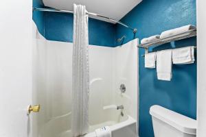 a bathroom with a shower and a white toilet at Rodeway Inn in West Memphis +23 photos
