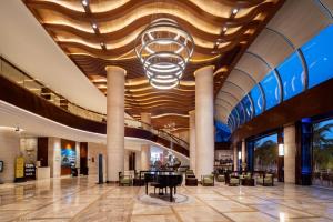 a lobby with a piano in the middle of a building at Grand Soluxe Hotel and Resort Sanya in Sanya