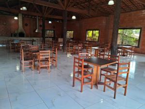 a dining room with wooden tables and chairs at Chácara Curuco in Mairinque