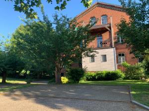 a large brick building with a tree in front of it at Alte Wassermühle in Lenzen