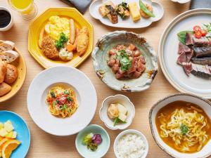 a table with plates of food and bowls of food at Mitsui Garden Hotel Kyoto Shijo in Kyoto