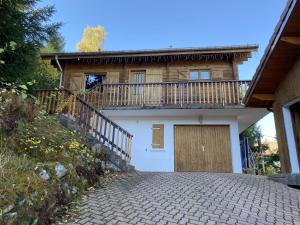 a house with a balcony and a driveway at Chalet de la Roche Gauthier in Gérardmer