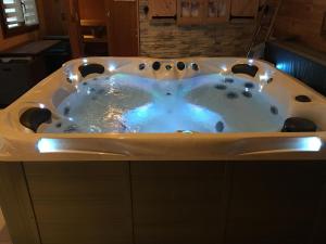 a bath tub filled with water in a bathroom at Chalet de la Roche Gauthier in Gérardmer +22 photos