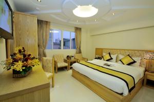 a hotel room with a bed and a television at Vuong Tai Hotel in Ho Chi Minh City