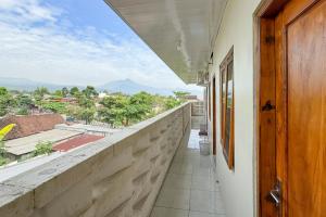 a room with a balcony with a view at RedDoorz Syariah Zidney Near Rejosari Salatiga in Salatiga
