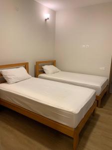 Khaira GaliPine Edge by T2R - Luxury Duplex Apartment Private Parking & Stunning Views in Khaira Gali near to Nathia Gali & Muree的一间白墙房间里有两张单人床
