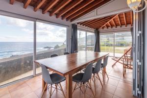 Un comedor con mesa y sillas y el océano. en Canto do Mar, en Mosteiros