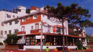 un gran edificio blanco con un árbol delante en Planet Punta del Este Hostel, en Punta del Este