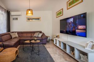 a living room with a couch and a flat screen tv at Villa Mediterranea, an idyllic new villa with a Mediterranean touch in Vinež