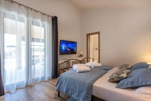 a bedroom with two beds and a tv and a window at Villa Mediterranea, an idyllic new villa with a Mediterranean touch in Vinež +22 photos