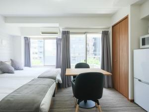 東京にあるITO House-伊藤家のベッドと机があるホテルの部屋