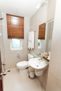 een witte badkamer met een toilet en een wastafel bij Blue Sky Phu Quoc Hotel in Phu Quoc