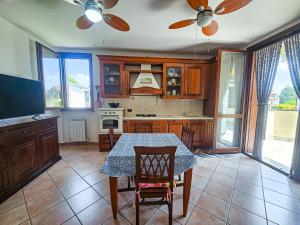 a kitchen with a table and a dining room at Malpensa Retreat in Ferno