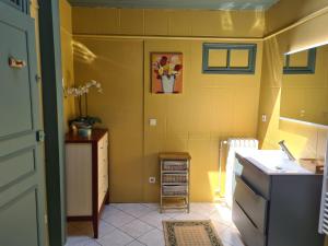 a yellow kitchen with a sink and a counter at Le Jardin Secret in Monflanquin +35 photos