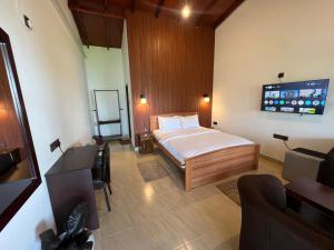 a bedroom with a bed and a tv in it at Blooming Rose Ella in Ella