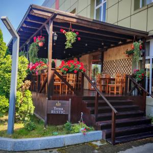 a restaurant with stairs and a table and flowers at My-RIN in Otopeni