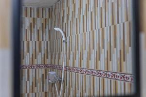 a shower in a bathroom with a mirror at The Sweet Corn Bungalow in Nusa Penida