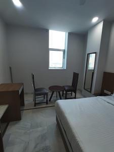 a bedroom with a bed and a table and chairs at Hotel Roshanee in Jaipur