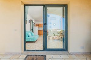 una puerta corredera de cristal que conduce a una sala de estar en Oltre Casa, en Porto San Paolo