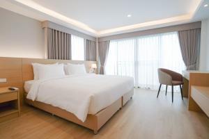 a hotel room with a large bed and a desk at The Kite Hotel Bangsaen by Koko in Ban Laem Thaen