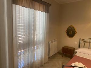 a bedroom with a bed and a window with white curtains at 4 Seasons in Altavilla Milicia +9 photos