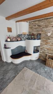 a living room with a couch and a brick wall at Zoe's Ferienwohnung in Kleinvolderberg