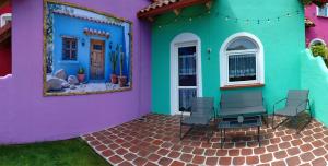 a colorful house with chairs sitting outside of it at Meksykańska Laguna in Debina