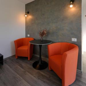 two orange chairs and a table in a room at LakeView Villas 