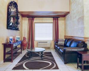 a living room with a leather couch and a table at Quality Inn & Suites Airport in Austin