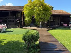 a garden with a wooden walkway in front of a house at בלב הגורן belevhagoren in Goren +11 photos