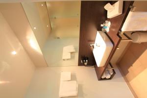 La salle de bains est pourvue d'un lavabo et d'un miroir. dans l'établissement Art Hotel Lauterbach, à Kaiserslautern