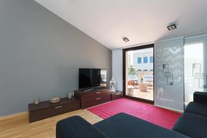 een woonkamer met een bank en een flatscreen-tv bij Matarolux 5 in Mataró