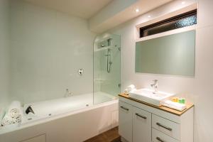 a bathroom with a tub and a sink and a shower at Crest On Barkly Serviced Apartments in Melbourne