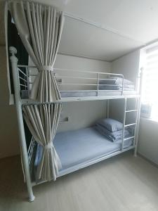 釜山FUNWAVE guest house的客房设有两张双层床和窗帘
