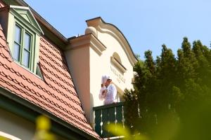 zwei Personen stehen auf einem Balkon eines Hauses in der Unterkunft Willa Deco Sopot by Downtown Apartments in Sopot