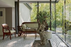ein Wohnzimmer mit einem Baum und einem Stuhl in der Unterkunft Willa Deco Sopot by Downtown Apartments in Sopot