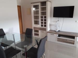 タンジェにあるAppartement neuf, lumineux et calme, entièrement meubléのダイニングルーム(ガラスのテーブル、椅子付) +3枚の写真